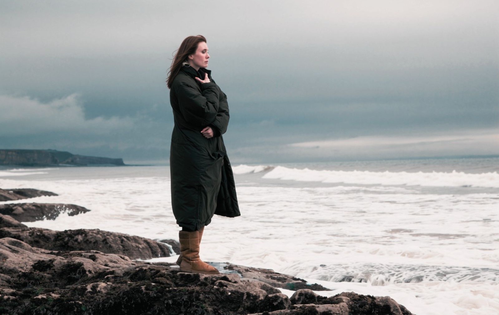 Woman on the edge of the ocean reflecting on how her world has changed.